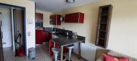 a kitchen with red cabinets and a black counter top at Next to Golf-club House in Talmont