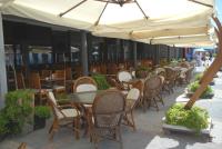 una fila di tavoli e sedie sotto un ombrellone di Sunday Beach Hotel a Kusadası