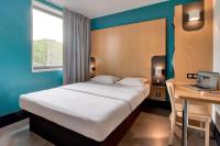 Un dormitorio con una cama y un escritorio con una computadora portátil. en B&amp;B HOTEL Bayonne Tarnos, en Tarnos