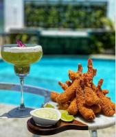 un drink e un piatto di cibo accanto alla piscina di Hotel Espadarte a Iriri