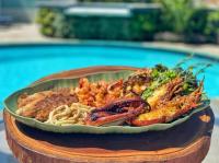 un piatto di cibo con frutti di mare e pasta su un tavolo di Hotel Espadarte a Iriri