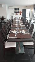 a long table with chairs and wine glasses on it at Citotel Hôtel Le Capricorne in Marmande