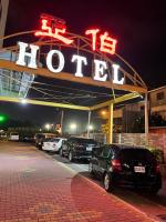 a hotel sign with cars parked in a parking lot at Abbo Hotel in Tainan