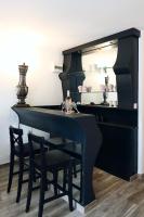 a black dining room table with chairs and a mirror at la Romana Luxe et sérénité au cœur de Saint-Tropez Suites spacieuses avec jardin enchanteur in Saint-Tropez