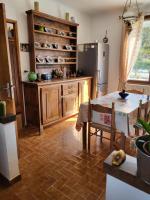 a kitchen with a table and a refrigerator at Domaine du gros pata in Vaison-la-Romaine