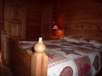 a bedroom with a wooden bed in a wooden cabin at Gîte Le Menil, 5 pièces, 5 personnes - FR-1-589-107 in Le Ménil