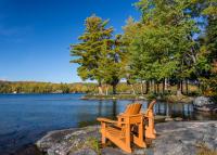 two chairs sitting on a rock next to a lake at Sherwood Inn in Port Carling