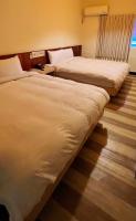 a hotel room with two beds and a window at Hwa Hong Hotel in Kaohsiung