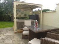 a patio with a gazebo and a grill at Garden Suite in Rhuddlan