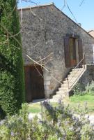 a stone house with a wooden door and stairs at Gite un toit sur la Doa in Apt