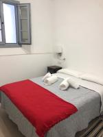 a bedroom with a large bed with a red blanket at Apartamentos Casa la Costanilla in Vejer de la Frontera