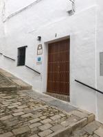 a white building with a brown door on it at Apartamentos Casa la Costanilla in Vejer de la Frontera