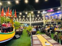 a boat on the grass with people sitting at tables at Hotel Kollol by J&Z Group in Cox's Bazar