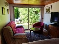 a living room with a couch and a table and a television at Gîte 2 personnes, proche mer in Challans