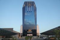 Un edificio alto de cristal con un cartel. en Tulip Plaza Hotel, en Sakaka