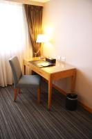 a desk with a chair and a lamp in a room at Fushin Hotel - Tainan in Tainan