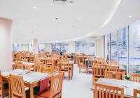 ein Esszimmer mit Tischen, Stühlen und Fenstern in der Unterkunft Retal View North Coast Aqua Park in El-Alamein