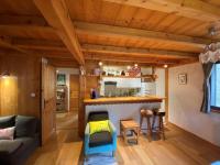 a kitchen and living room in a log cabin at Appartement cosy au pied du MtBlanc in Chamonix