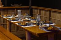 een houten tafel met borden met eten erop bij TABARI DIVE LODGE in Pulau Mansuar