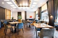 Un comedor con mesas y sillas de madera. en Van der Valk Hotel Spa, en Spa