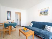 a living room with a blue couch and a table at Apartment Marin&#39;Land by Interhome in La Grande Motte
