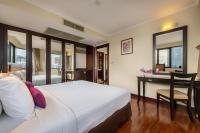 a hotel room with a bed and a desk at Bandara Suites Silom, Bangkok in Bangkok