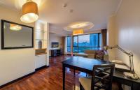 a living room with a table and a large window at Bandara Suites Silom, Bangkok in Bangkok