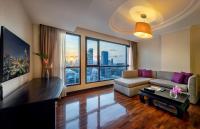a living room with a couch and a large window at Bandara Suites Silom, Bangkok in Bangkok