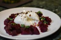 Un plato blanco con un postre con un huevo escalfado encima. en Hotel Parister Piscine & Spa, en París