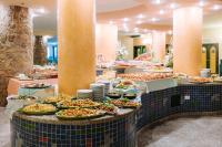 una linea di buffet con molti piatti di cibo di Nicolaus Club Torre Moresca a Cala Liberotto