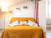 a bedroom with an orange bed with pillows on it at Apartment Berasteguia-5 by Interhome in Ciboure