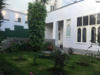 una casa blanca con un jardín delante en La casa de Teresita, en La Paz