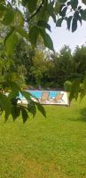 a pool with two lounge chairs in the grass at Chambre Lily in Parranquet