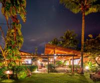 a house at night with palm trees and lights at Villa Sapê Pousada in Ubatuba