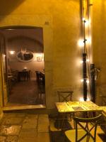 een eetkamer met een tafel, stoelen en een spiegel bij Casa 28 in Canosa di Puglia