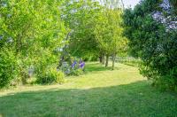 a garden with trees and grass and purple flowers at La Pause Céleste in Ordonnac