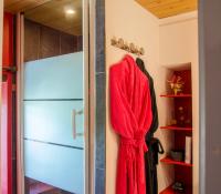 a red towel hanging on a door in a bathroom at La Pause Céleste in Ordonnac