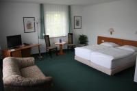 a bedroom with a bed and a desk and a chair at Hotel &amp; Restaurant Bergfried in Saalfeld