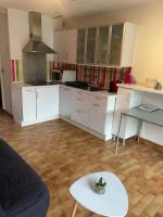 a kitchen with white cabinets and a white table at Appartement avec jardin Gruissan in Gruissan