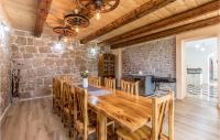 a large wooden table in a room with a stone wall at Awesome Home In Vinjani Donji With 5 Bedrooms, Wifi And Outdoor Swimming Pool in Bilopavlovići