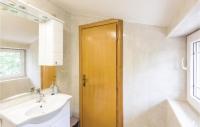 a bathroom with a sink and a wooden door at Awesome Home In Vinjani Donji With 5 Bedrooms, Wifi And Outdoor Swimming Pool in Bilopavlovići