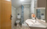 a bathroom with a sink and a toilet and a mirror at Awesome Home In Vinjani Donji With 5 Bedrooms, Wifi And Outdoor Swimming Pool in Bilopavlovići