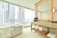 a bathroom with a large tub and a large window at Eastin Grand Hotel Sathorn in Bangkok