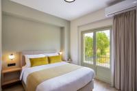 a bedroom with a bed and a large window at Dandelion apartments in Chania Town