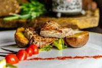 un plato de comida con carne, patatas y hortalizas en Hotel Petit Dahu - Chambres et Restaurant, en Cogne