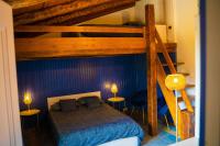 a bedroom with a bunk bed and two chairs at Au Temps Suspendu in Saint-Martin-dʼOydes