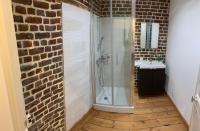 a bathroom with a walk in shower next to a brick wall at VIEUX LILLE Porte de Gand Bienvenue chez NESTYOU, Lille in Lille