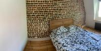 a bedroom with a bed next to a brick wall at VIEUX LILLE Porte de Gand Bienvenue chez NESTYOU, Lille in Lille