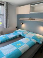two beds in a bedroom with blue and yellow sheets at Chalet Max II in Helming