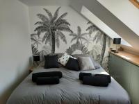 a bedroom with a bed with palm trees on the wall at La Maison du Quai Triplex de charme 4 étoiles en hyper centre avec SPA in Landerneau